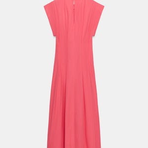 May include: A solid coral pink midi dress featuring short cap sleeves, a round neckline, and a vertical keyhole opening at the upper back. The garment has a fitted bodice with subtle vertical pleats that transition into a flared skirt.