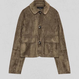May include: A cropped olive green jacket with a soft suede-like texture, featuring a classic collar, long sleeves, and two large front patch pockets. The garment is fastened with three dark, marbled buttons down the center front placket.