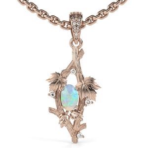May include: Rose gold pendant necklace featuring a nature-inspired design. The pendant showcases an oval opal gemstone, framed by delicate leaves and branches. Small, sparkling diamonds accent the design. The necklace chain is also rose gold.