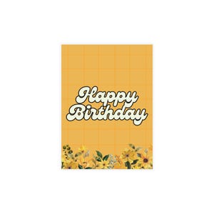 May include: A rectangular birthday card with a yellow grid pattern background. The words "Happy Birthday" are written in a retro font. The bottom of the card has a floral design with yellow and green flowers.