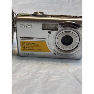 以下が含まれることがあります： 3倍光学非球面レンズを備えたシルバーのKodak M753デジタルカメラ。 HD静止画キャプチャ、デジタルIS、7.0メガピクセルなどの機能があります。 カメラには内蔵フラッシュと37mm-111mmのレンズが付いています。