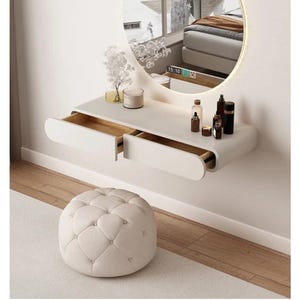 Peut inclure: Une coiffeuse blanche moderne avec un miroir rond et des tiroirs intégrés. La coiffeuse est fixée au mur et comprend un petit pouf capitonné. Le miroir reflète une chambre. Divers produits cosmétiques sont exposés.