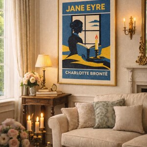 Può includere: Un poster incorniciato di "Jane Eyre" di Charlotte Brontë è appeso sopra un divano color crema. Il poster presenta la silhouette di una donna che legge alla luce delle candele. La stanza è decorata con una lampada, fiori e candele, creando un'atmosfera accogliente.