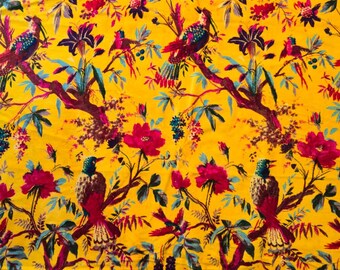 May include: A vibrant yellow fabric featuring a repeating pattern of colorful birds perched on branches with pink flowers and green leaves. The birds have red, blue, and green plumage.