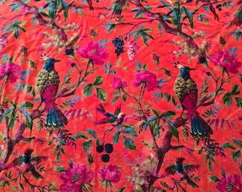 May include: A vibrant red fabric featuring a detailed floral and bird pattern. The design includes pink roses, green leaves, and colorful birds with blue, green, and red plumage. The overall aesthetic is reminiscent of a botanical illustration.