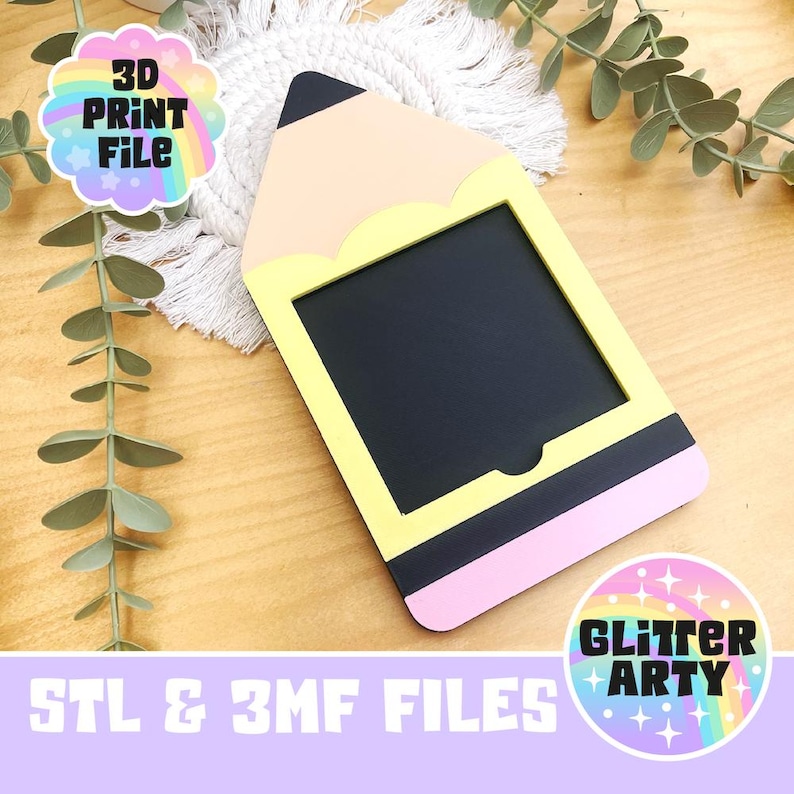 Pu&ograve; includere: Una cornice a forma di matita con interno nero, bordo giallo ed estremit&agrave; rosa a gomma. La parte superiore &egrave; beige con una punta nera. Il testo "3D PRINT FILE" e "STL & 3MF FILES" &egrave; incluso.
