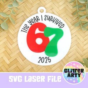 May include: White circular ornament with the text "The year I survived" and the numbers "67" in red and green, with the year "2025" below. The ornament has a hole at the top for hanging. The bottom of the image has the text "SVG Laser File".