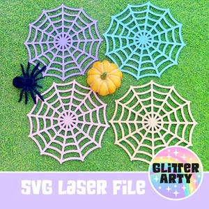 Könnte beinhalten: Vier lasergeschnittene Spinnennetz-Designs in Pastellfarben: Lavendel, Blau, Rosa und Beige. Ein kleiner orangefarbener Kürbis und eine schwarze Spinne sind ebenfalls vorhanden. Der Text "SVG Laser File" und ein Logo "Glitter Arty" sind enthalten.