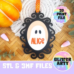 May include: A black oval-shaped ornament with an ornate scrollwork frame, featuring a white center with a ghost graphic and the orange text ALICE. It hangs from an orange ribbon with white polka dots. Includes 3D PRINT FILE and GLITTER ARTY text.