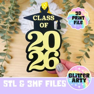 May include: A black and yellow graduation ornament with the text "CLASS OF 2026". The ornament is shaped like a graduation cap and has a yellow ribbon for hanging. The image also includes the text "3D PRINT FILE" and "GLITTER ARTY".