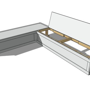 May include: A gray, L-shaped storage bench with a hinged lid. The bench is constructed of wood and has a simple, modern design. The lid is open, revealing the interior storage space.