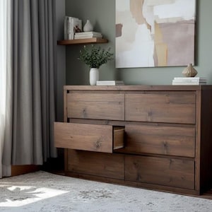 以下が含まれることがあります： 温かみのあるブラウン仕上げの、6つの引き出しが付いた木製ドレッサー。 引き出しの1つが開いており、内部が見えます。 ドレッサーは、ニュートラルな色使いの部屋にあり、ラグと絵画があります。