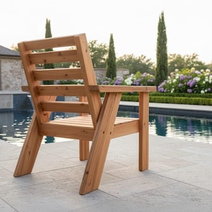 以下が含まれることがあります： 背もたれとアームレストが付いた木製のアウトドアチェア。椅子は明るい色の木材で作られており、プールの近くに配置されています。椅子のデザインはシンプルで頑丈で、パティオや庭に適しています。
