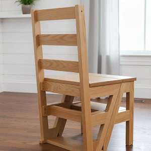 May include: A wooden step chair with a light oak finish. The chair has a ladder-style back with three horizontal slats and a seat that folds out to create a step. The chair is designed for both seating and reaching higher objects.