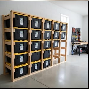 May include: A wooden storage shelf unit filled with black plastic bins with yellow lids. The unit is constructed from light-colored wood and is against a white wall. The bins are organized in multiple rows and columns.