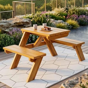 May include: A wooden picnic table with attached benches. The table and benches are made of light-colored wood and are set on a white rug with a geometric pattern. Two mugs and a plate of food are on the table.