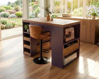 May include: A purple and wood-toned sewing table with a brown leather bar stool. The table has built-in storage and a wooden countertop. A sewing machine and other craft supplies are visible. The room has large windows overlooking a garden.
