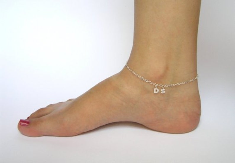 May include: Silver ankle bracelet with a charm that says "DS".