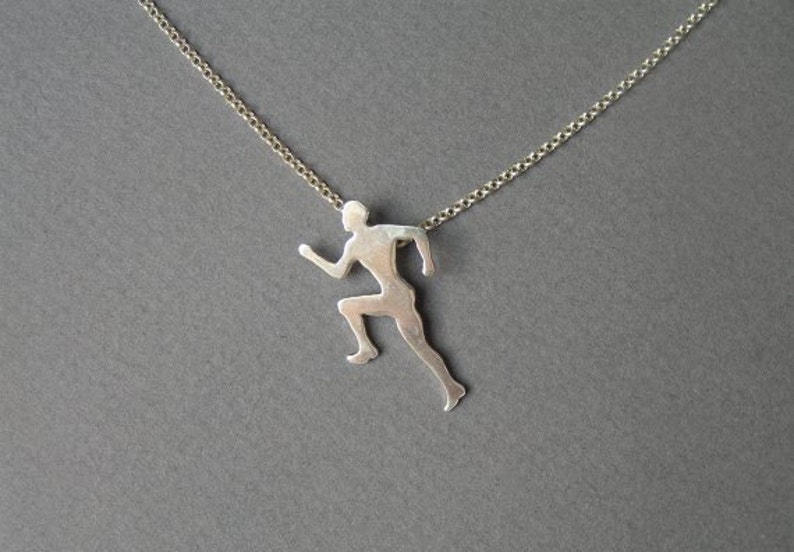 May include: A silver necklace with a pendant shaped like a running person.