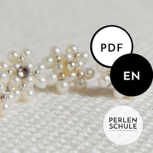 Könnte beinhalten: Nahaufnahme von Ohrringen mit Perlen. Jeder Ohrring hat ein Blumenmuster aus kleinen, weißen Perlen und einem zentralen Strassstein. Der Hintergrund ist weiß und strukturiert. Der Text 'PDF' und 'EN' ist ebenfalls sichtbar.