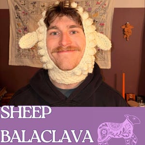 Puede incluir: Una balaclava de oveja de ganchillo de color crema. La balaclava presenta un diseño de cara de oveja con orejas y un aspecto lanoso texturizado. El texto "SHEEP BALACLAVA" se muestra en blanco, con "By Lilac Cowboy Creations" debajo. También se incluye un gráfico de oveja púrpura.