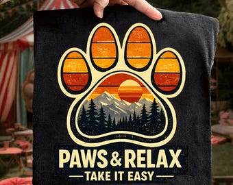 May include: Black square fabric with a paw print design. The paw print features a sunset scene with mountains and trees. The text "PAWS & RELAX - TAKE IT EASY" is printed below the paw print.