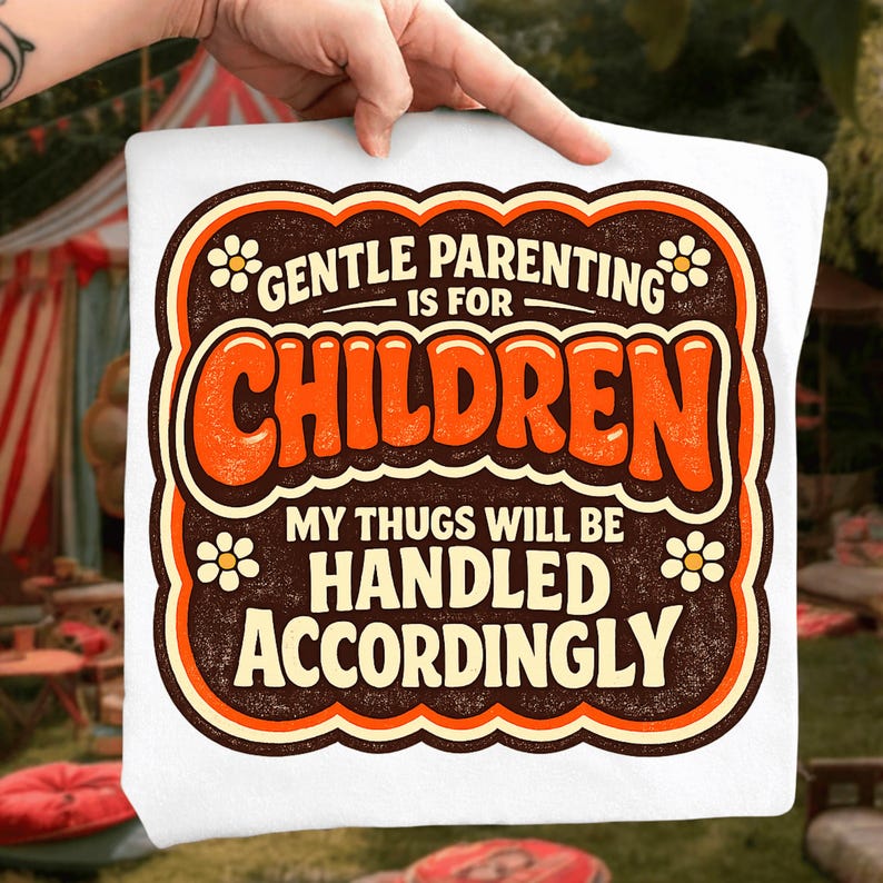 K&ouml;nnte beinhalten: Wei&szlig;es T-Shirt mit Retro-Design. Das Design zeigt den Text "GENTLE PARENTING IS FOR CHILDREN" in brauner und orangefarbener Schrift, darunter der Satz "MY THUGS WILL BE HANDLED ACCORDINGLY". Das Design ist von einem braunen Rahmen und kleinen Blumenakzenten umgeben.