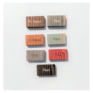 May include: Wood samples stained in various colors, including dark walnut, light walnut, gray, blue, aqua, red, and black.