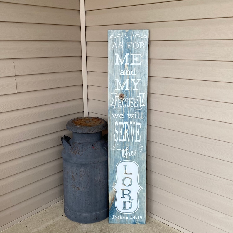 May include: A wooden sign with a blue and white distressed paint finish. The sign reads "As for me and my house we will serve the Lord. Joshua 24:15"
