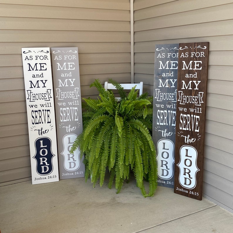 May include: Four wooden signs with white text on a gray, brown, and white background. The signs read "As for me and my house we will serve the Lord" with the scripture reference "Joshua 24:15".