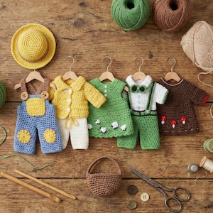 May include: A collection of handmade crochet baby clothes in various colors, including blue overalls, a yellow jacket, a green dress with sheep, and a brown top with mushrooms. A yellow hat and a small brown basket are also present.