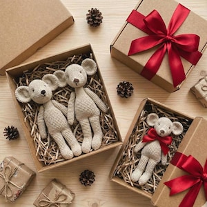 Puede incluir: Varias mu&ntilde;ecas de rat&oacute;n de ganchillo en cajas de cart&oacute;n llenas de paja. Algunas cajas est&aacute;n atadas con cinta roja. Las mu&ntilde;ecas son beige con orejas grandes y est&aacute;n rodeadas de pi&ntilde;as. Tema de regalo.