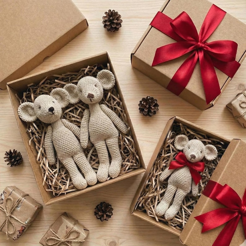 Puede incluir: Varias mu&ntilde;ecas de rat&oacute;n de ganchillo en cajas de cart&oacute;n llenas de paja. Algunas cajas est&aacute;n atadas con cinta roja. Las mu&ntilde;ecas son beige con orejas grandes y est&aacute;n rodeadas de pi&ntilde;as. Tema de regalo.