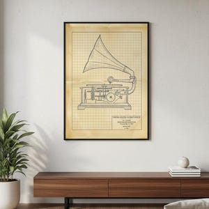 May include: Framed vintage blueprint of a gramophone. The black and white illustration is set against a grid background, with text from the United States Patent Office. The artwork is displayed in a black frame.