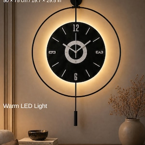 Könnte beinhalten: Eine moderne schwarze Wanduhr mit kreisförmigem Design und warmer LED-Beleuchtung. Das Zifferblatt ist schwarz mit weißen Ziffern und Zeigern. Die Uhr misst 50 x 75 cm. Der Text "Warm LED Light" ist sichtbar.