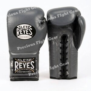 May include: A pair of grey leather boxing gloves featuring black laces and the Cleto Reyes logo on the wrist and back of the hand. The gloves are marked with 14oz on a small white tag. The text Cleto Reyes Hecho en Mexico is visible.