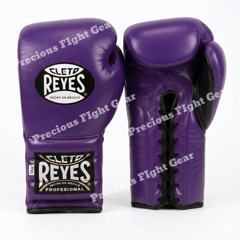 May include: A pair of purple boxing gloves with black laces and black trim. The gloves feature a white and black Cleto Reyes logo patch on the wrist and the back of the hand, with the text 14oz printed on the wrist label, indicating the weight.