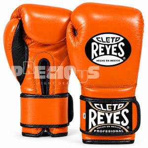Peut inclure: Une paire de gants de boxe orange vif avec des bordures et des lacets noirs. Les gants présentent le logo Cleto Reyes dans un ovale noir sur le dos de la main et un écusson rectangulaire sur la sangle du poignet indiquant Cleto Reyes Hecho En Mexico.