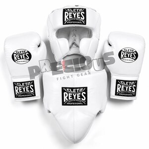 Peut inclure: Un ensemble d'équipement de boxe blanc comprenant deux gants de boxe, un casque et une coquille. Chaque pièce présente un écusson logo noir et blanc Cleto Reyes avec le texte Cleto Reyes Hecho en Mexico Profesional.