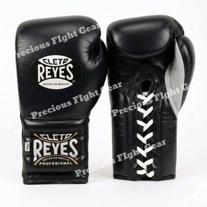 May include: A pair of black Cleto Reyes boxing gloves with white laces. The gloves feature the Cleto Reyes logo and the text 'HECHO EN MEXICO' and 'PROFESIONAL'. A small tag on the wrist indicates a weight of 14oz for these professional gloves.