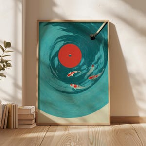 Op de afbeelding: Een ingelijste kunstdruk met een ontwerp van een turquoise vinylplaat met een rode kern en koi-karpers die in de groeven zwemmen. Het kunstwerk heeft een houten lijst en staat op een houten vloer.