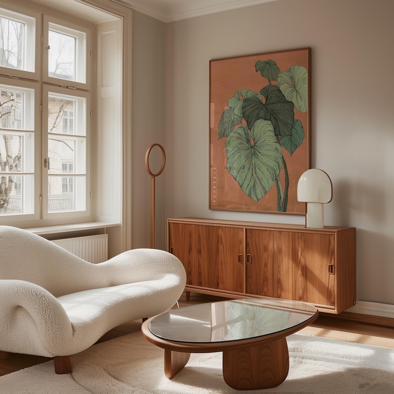 May include: A living room scene featuring a white, curved sofa, a wooden coffee table with a glass top, and a wooden cabinet. A large framed botanical print hangs above the cabinet. A white lamp and a wooden floor lamp are also present.