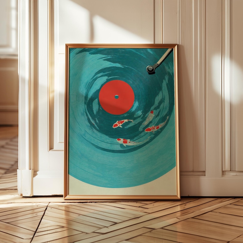 Op de afbeelding: Ingelijste kunstdruk met een turquoise vinylplaatontwerp met koi-karpervissen die in de groeven zwemmen. Het midden van de plaat is rood en het kunstwerk zit in een gouden lijst. De afbeelding wordt op een houten vloer weergegeven.