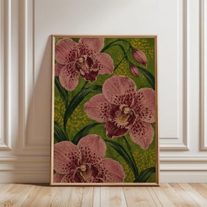 May include: A framed botanical print featuring three large, detailed pink orchids with dark purple speckled patterns. The flowers are set against a vibrant green background with thin, dark green leaves and small clusters of yellow accents.