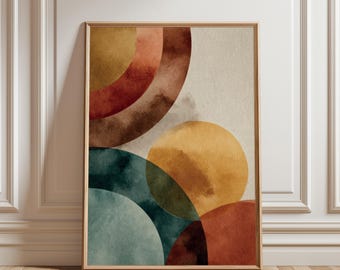 Puede incluir: Impresión artística abstracta con círculos de acuarela superpuestos en tonos óxido, dorado, verde azulado y marrón. La obra de arte está enmarcada en un marco de madera natural y se apoya en una pared blanca y un suelo de madera.