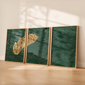 May include: Three framed art prints depicting a tiger swimming in a dark green wavy background. The tiger has gold and orange fur with black stripes. The frames are light wood, and the theme is nature and wildlife. The prints are in cm.