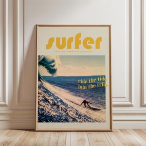 May include: Framed poster with a surfing theme. The poster features a surfer riding a wave, with the words "surfer" and "ride the tide join the tribe" in yellow text. The background shows a blue ocean and sky.