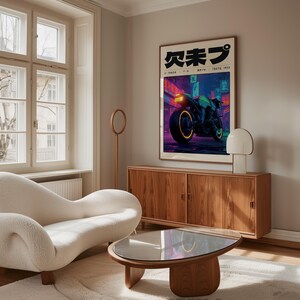 Puede incluir: Un p&oacute;ster enmarcado con una motocicleta de ne&oacute;n en una ciudad futurista. Texto japon&eacute;s en la parte superior. La obra de arte est&aacute; sobre un mueble de madera. Un sof&aacute; blanco curvado y una mesa de centro redonda est&aacute;n en primer plano.