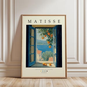 May include: A framed art print featuring a window view with blue shutters, overlooking a coastal scene. The print includes the text "MATISSE" at the top and "THE GALLERY COLLECTION" at the bottom, with oranges hanging from a tree.