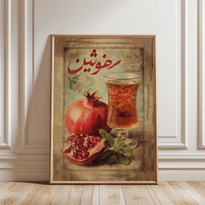 May include: Vintage-style framed print featuring a pomegranate, a glass of tea, and mint leaves. The pomegranate is whole and cut open, revealing its seeds. The print has text in a foreign language and is set against a faded background.